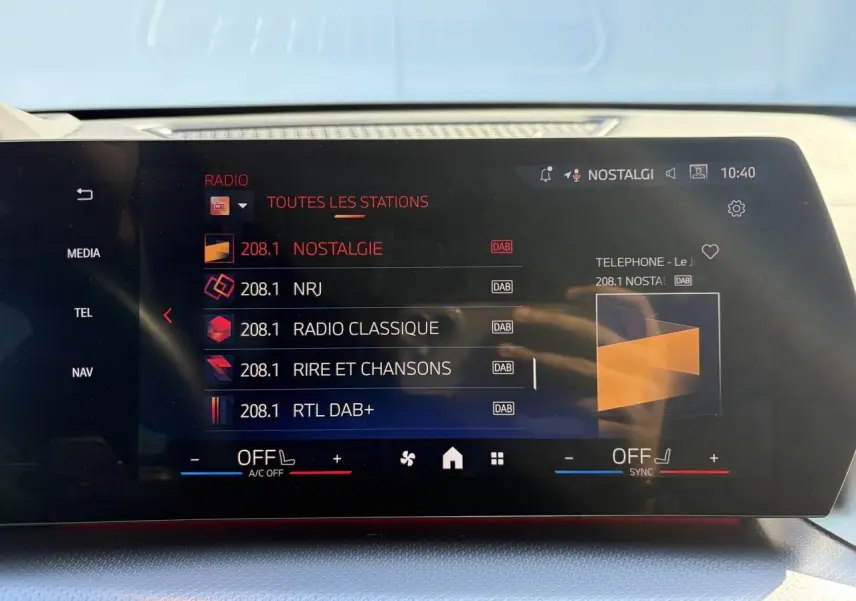 Écran tactile incurvé de la BMW X1 noir saphir, affichant la liste des stations radio en mode DAB.