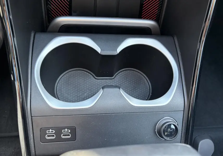 Gros plan sur la console centrale noire avec porte-gobelets et deux ports USB-C du BMW X1 noir Saphir 2025.