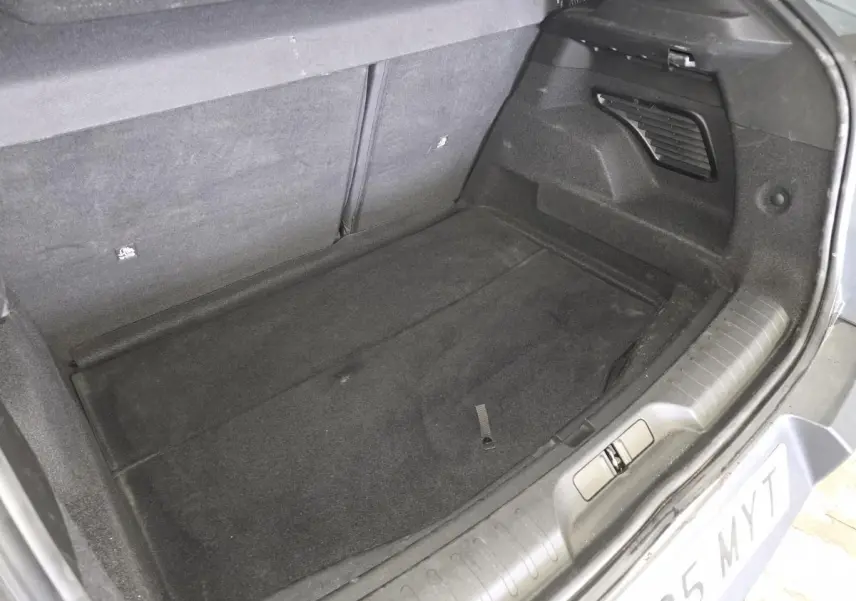 Coffre ouvert vu de dessus d'une Alfa Romeo Junior 1.2 Ibrida gris, montrant un espace de chargement propre et vide.