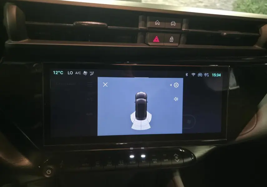 Écran tactile central de l'Alfa Romeo Junior 1.2 Ibrida 2025 montrant l'aide au stationnement en vue de dessus.