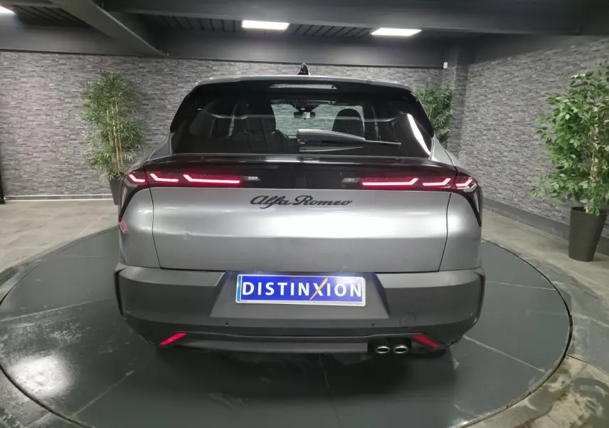 Vue arrière d'une Alfa Romeo Junior 1.2 Ibrida gris métallisé avec feux arrière LED et double sortie d'échappement.