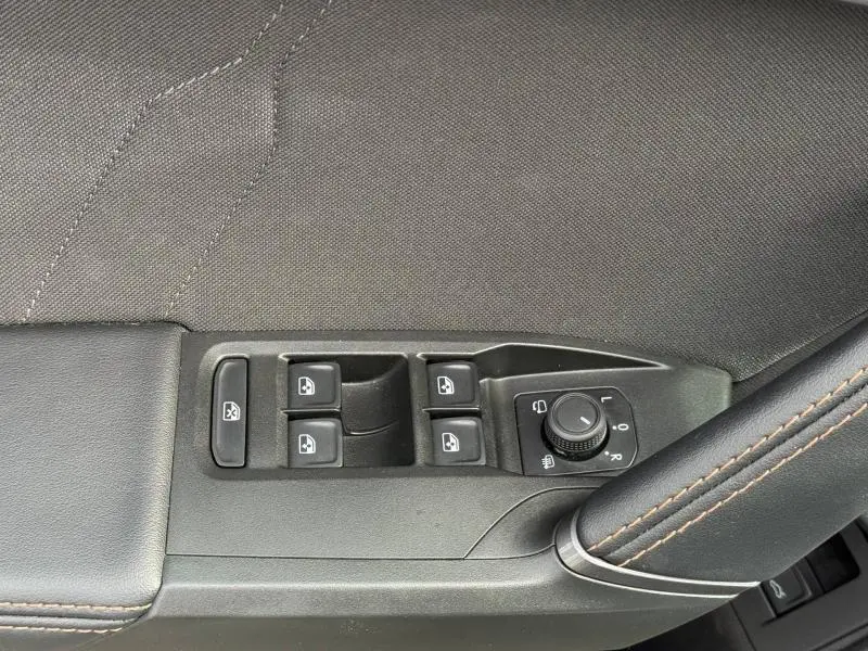 Gros plan sur les commandes des vitres et des rétroviseurs sur la porte côté conducteur d'un CUPRA Formentor.