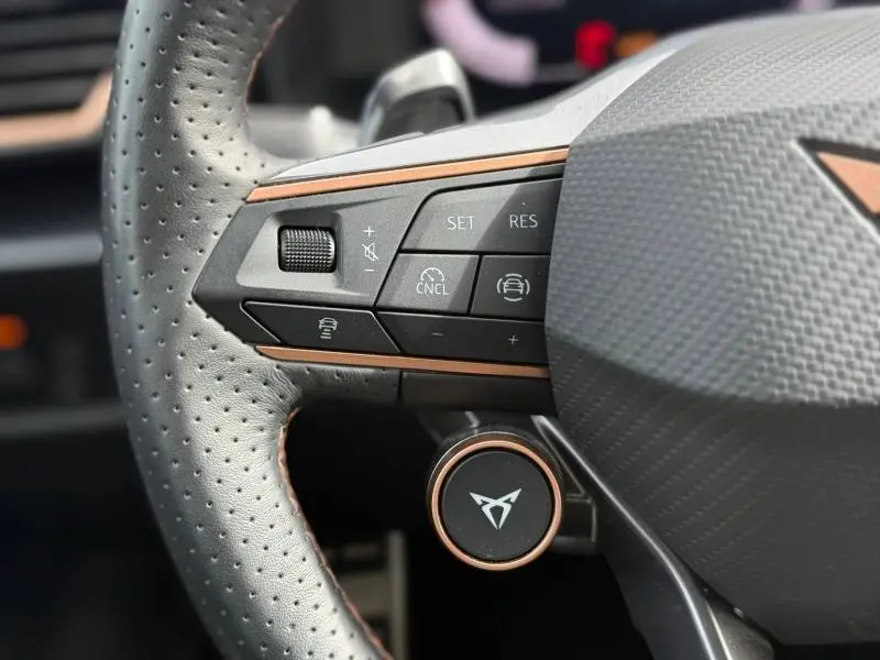 Gros plan sur le volant perforé de la CUPRA Formentor 2025 avec commandes multifonctions et détails cuivrés.