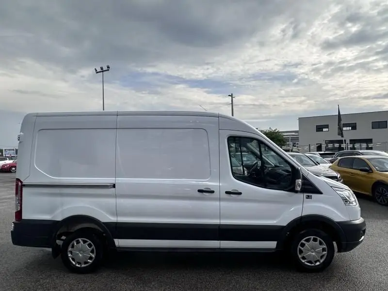 Vue de profil côté droit d'un Ford Transit Fourgon blanc T310 L2H2 avec bande noire basse et roues acier.