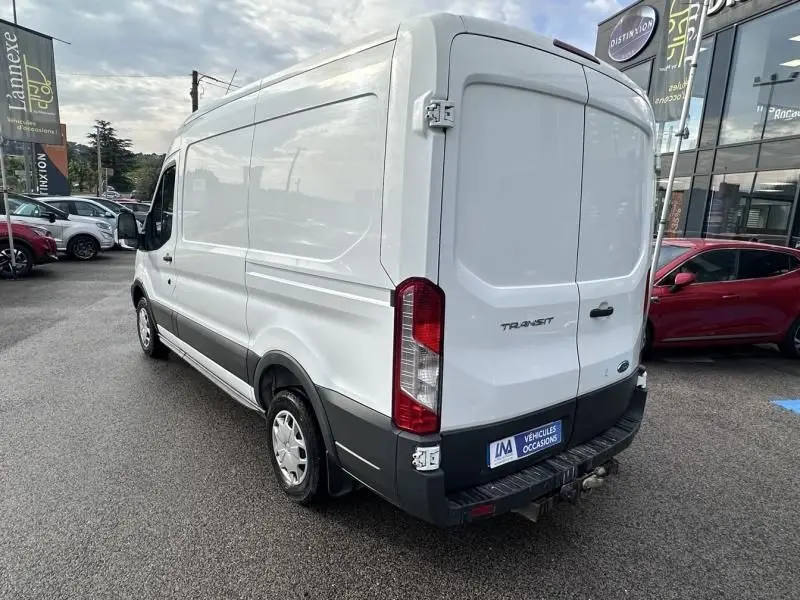 Vue 3/4 arrière droite d’un fourgon Ford Transit blanc de 2019 avec hayon arrière fermé et pare-chocs noir.