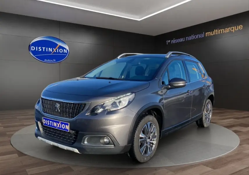 Peugeot 2008 gris foncé vue 3/4 avant droit avec toit ouvrant et jantes alliage en showroom.