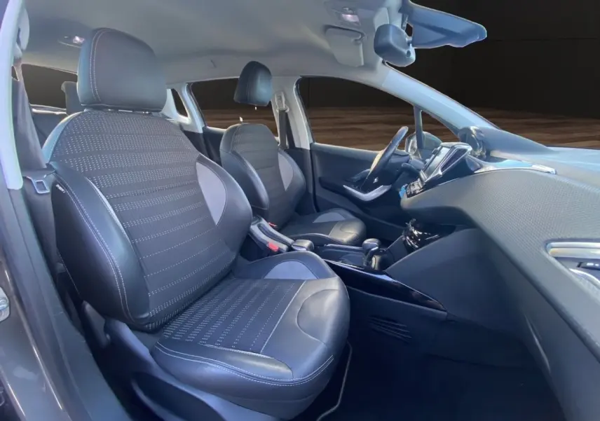 Vue intérieure avant droite du Peugeot 2008 2019, sièges en tissu et cuir noir avec surpiqûres blanches.