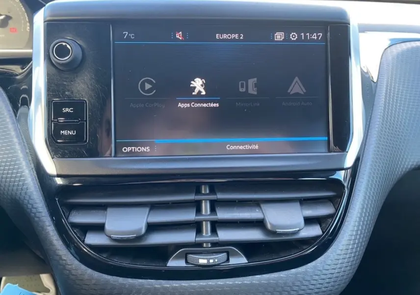 Vue rapprochée de l’écran tactile central du tableau de bord du Peugeot 2008 gris foncé, affichant les apps connectées.