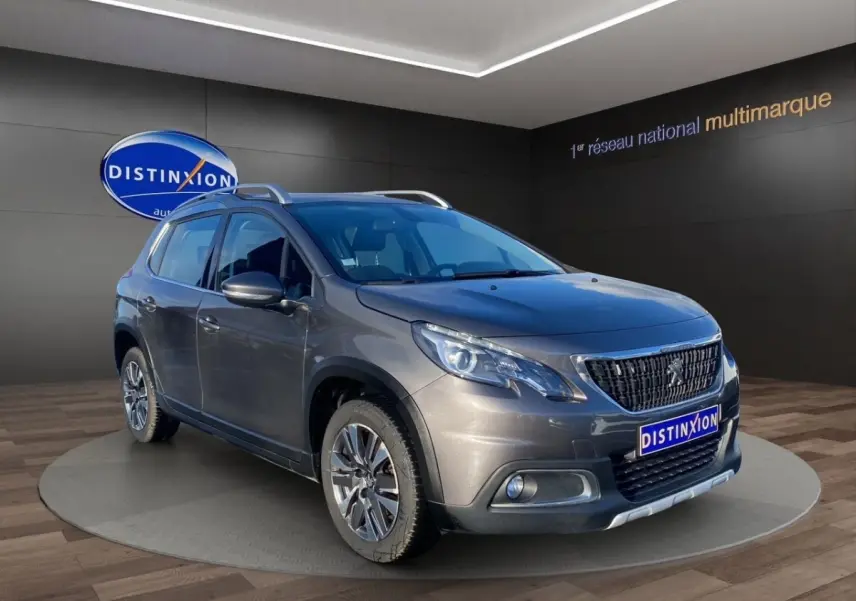 Peugeot 2008 gris foncé vue 3/4 avant droit, avec toit ouvrant et jantes alliage distinctives.