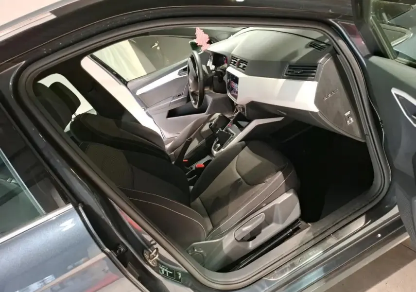 Intérieur du SEAT Arona gris foncé 2021 vu côté conducteur, avec tableau de bord clair et sièges noirs.