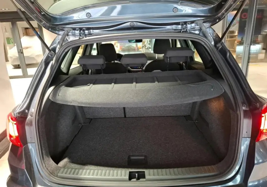 Vue arrière du coffre ouvert d'un SEAT Arona gris foncé 2021, mettant en valeur l'espace de chargement et la tablette cache-bagages.