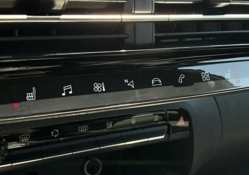 Détail du tableau de bord noir brillant de la Citroën C5 Aircross Hybrid avec commandes tactiles et sièges chauffants activés.