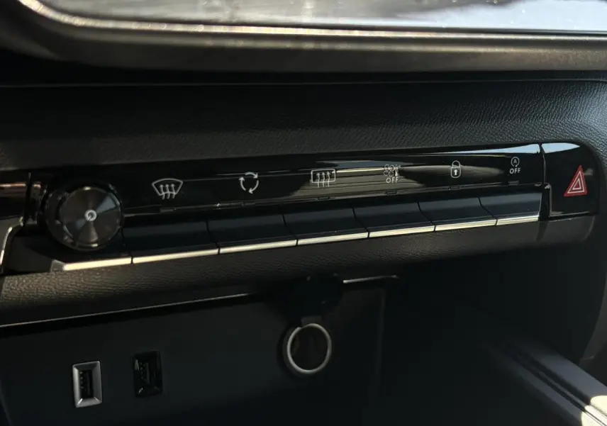 Détail de la console centrale noire du Citroën C5 Aircross Hybrid 2025 avec commandes climatisation et ports USB visibles.