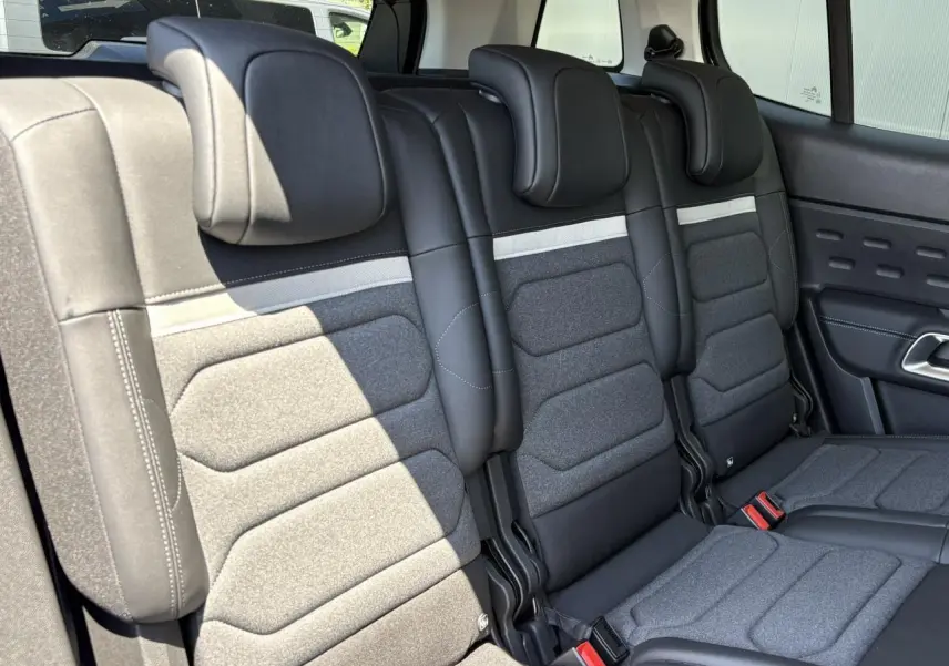 Vue rapprochée des trois sièges arrière indépendants en tissu gris et cuir noir du Citroën C5 Aircross Hybrid 2025.