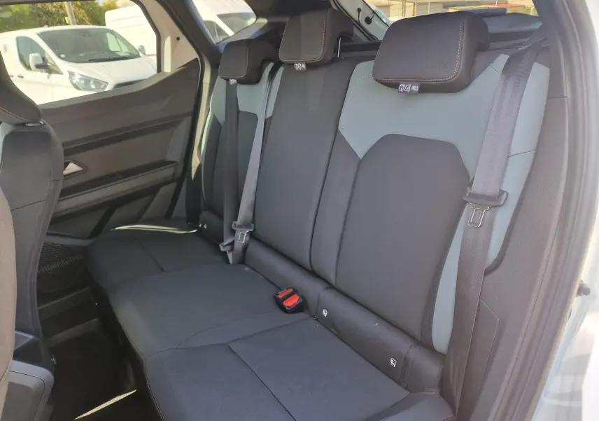 Vue intérieure du siège arrière droit du Dacia Duster 2026 blanc, montrant les appuie-têtes et ceintures de sécurité.