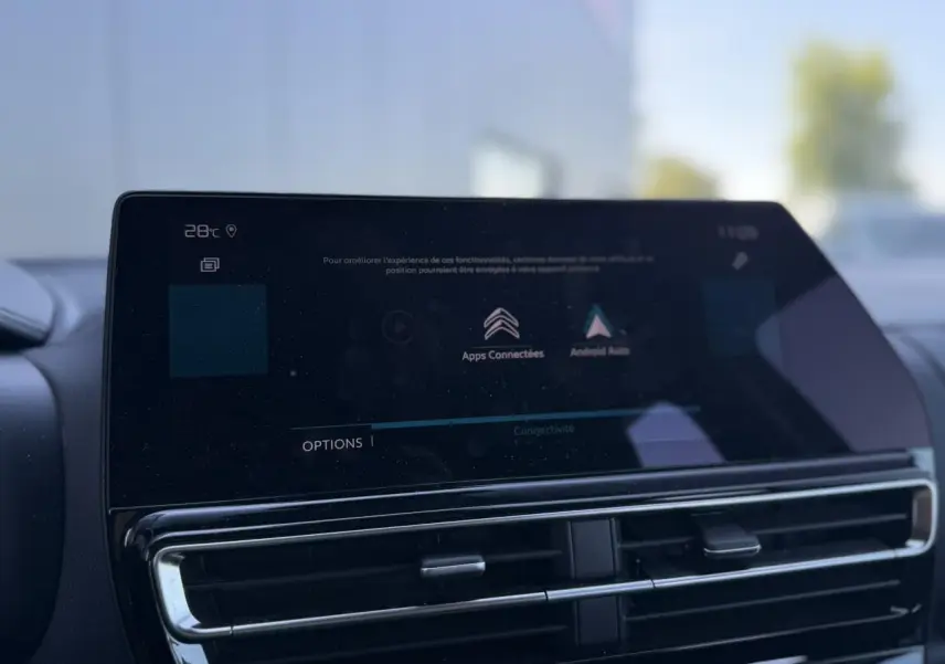 Gros plan sur l'écran tactile central et les aérateurs noirs brillants du tableau de bord du Citroën C5 Aircross Hybrid.