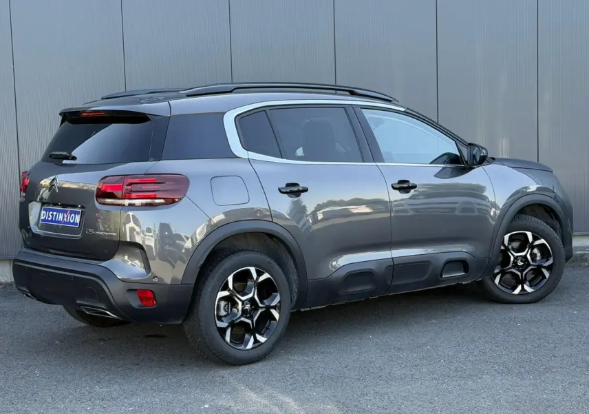 Vue 3/4 arrière droite du Citroën C5 Aircross Hybrid gris Platinium avec jantes bi-ton et toit noir.