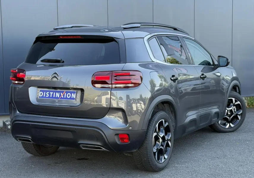 Vue 3/4 arrière droite d'un Citroën C5 Aircross Hybrid gris Platinium avec jantes alliage bi-ton et hayon électrique.