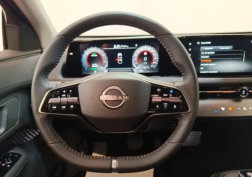 Vue frontale du volant cuir noir multifonctions du Nissan Ariya 2026 avec tableau de bord numérique et écran tactile.