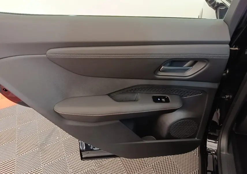 Gros plan sur la porte avant droite noire du Nissan Ariya 63kWh 218ch Engage avec commandes de vitre et haut-parleur intégré.