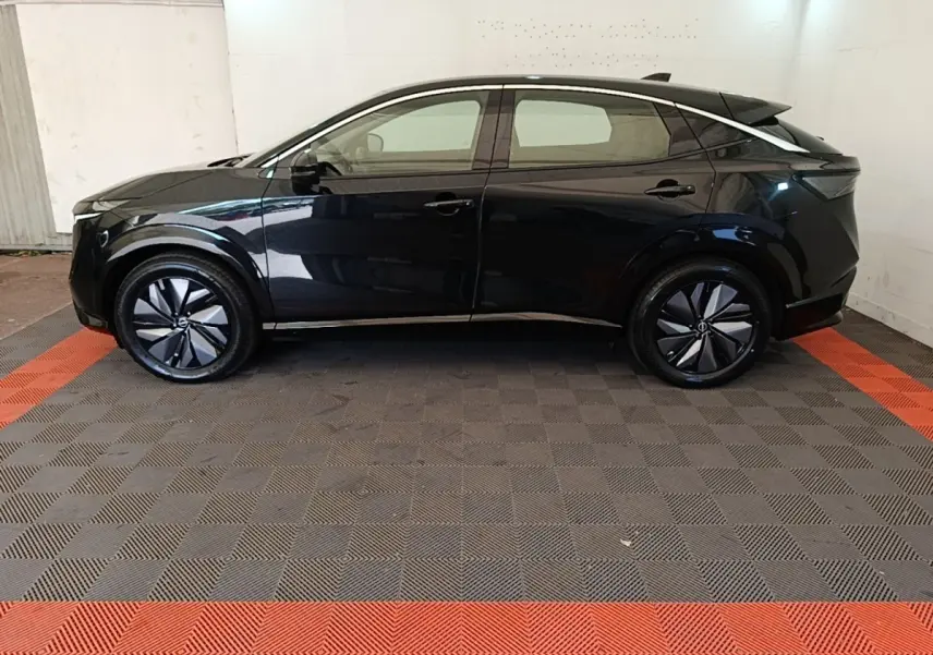 Vue de profil côté gauche du Nissan Ariya noir 63kWh 218ch Engage avec jantes modernes et lignes épurées.