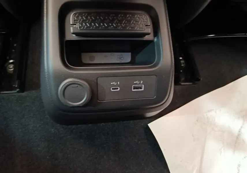 Vue rapprochée du rangement arrière avec prises USB-C et USB-A du Nissan Ariya noir 63kWh 218ch Engage 2026.