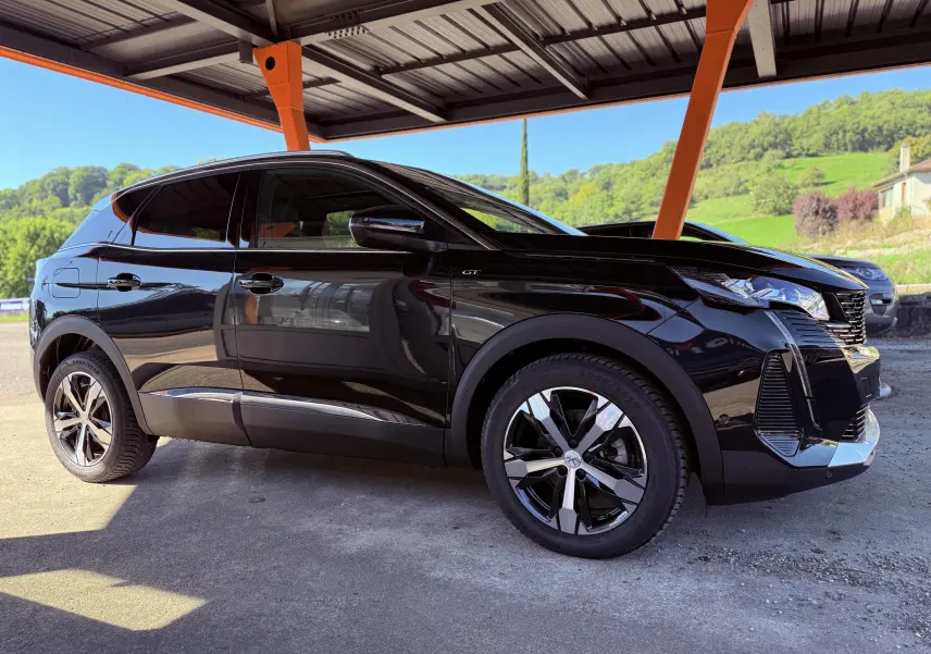 Peugeot 3008 noir perle métal vue de profil côté gauche sous un abri avec jantes alliage bicolores.