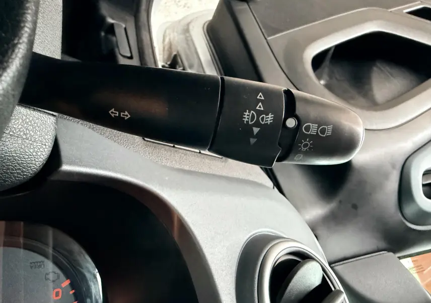 Gros plan sur la commande des phares et clignotants côté gauche du tableau de bord gris du Peugeot Partner Tepee 2014.