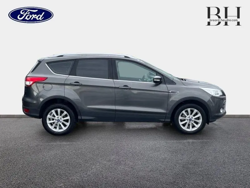 Vue latérale droite d'un Ford Kuga gris Magnetic de 2015 avec jantes alliage et vitres teintées.