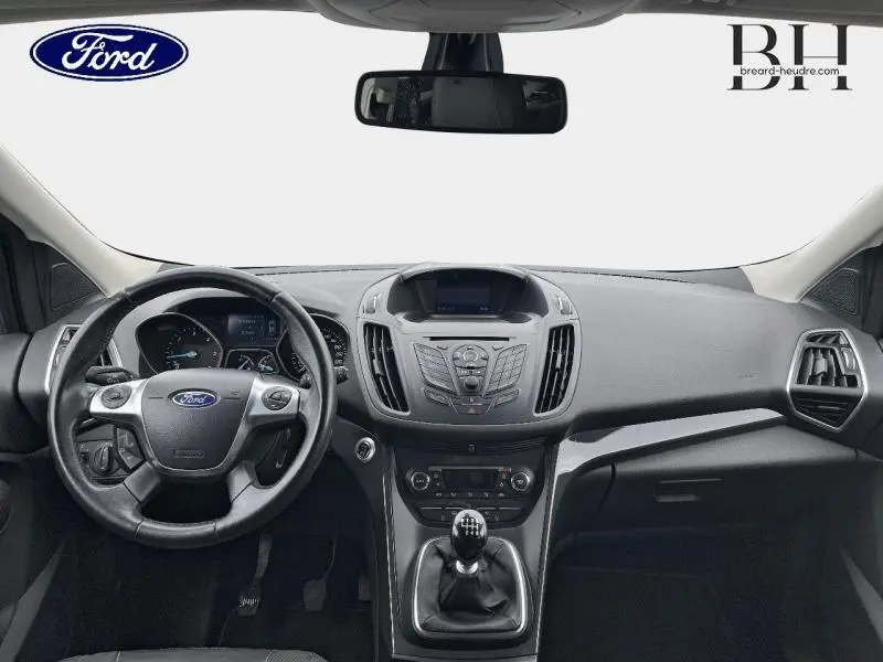 Vue intérieure frontale du tableau de bord et volant cuir multifonction du Ford Kuga gris Magnetic avec boîte manuelle.
