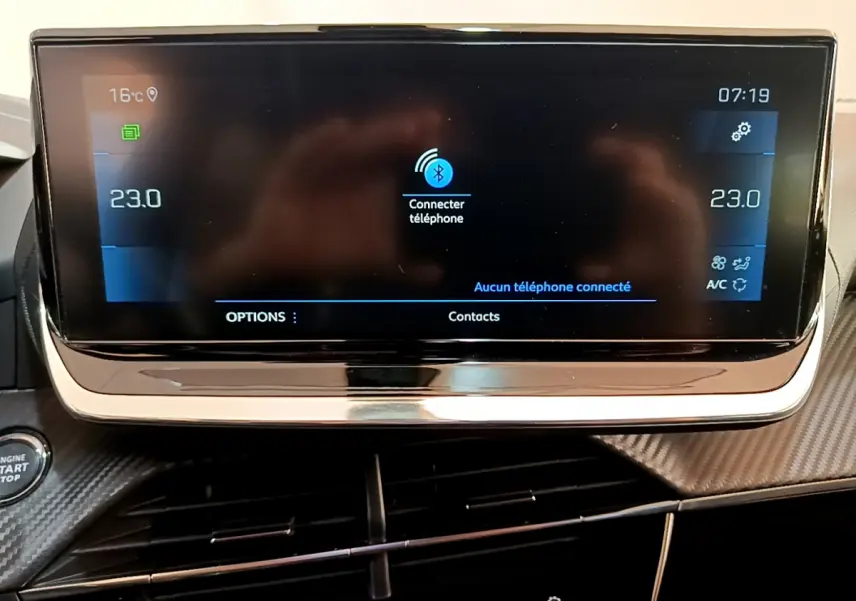 Écran tactile central noir du tableau de bord du Peugeot 2008 gris clair, affichant la connexion Bluetooth et la climatisation à 23°C.