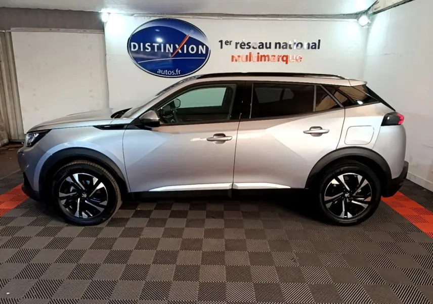 Peugeot 2008 gris clair vue de profil côté gauche, avec jantes noires et toit noir contrastant.