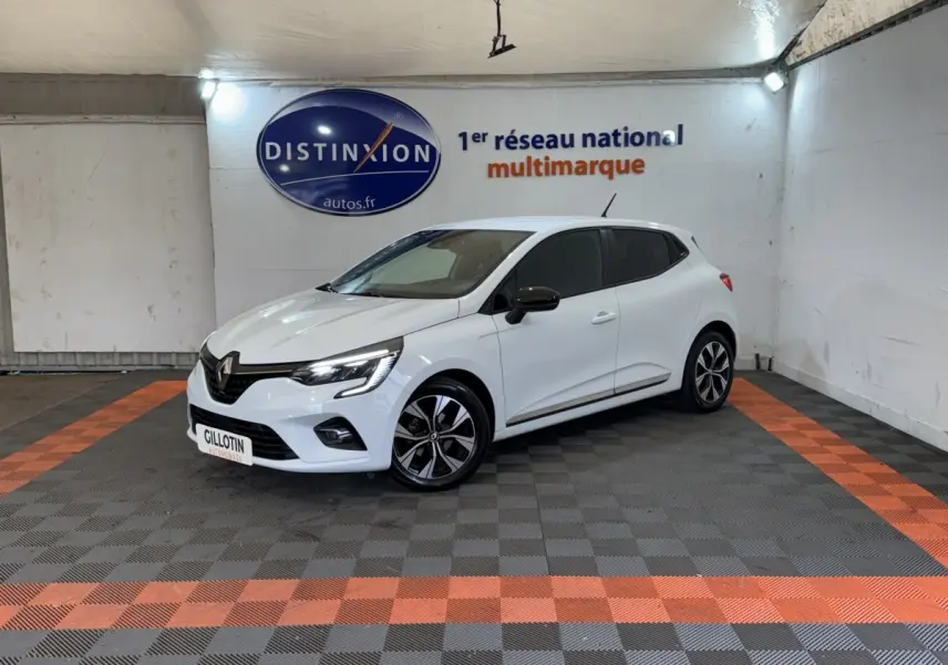 Renault Clio Business blanc vue 3/4 avant droit en intérieur avec jantes noires et rétroviseurs noirs.