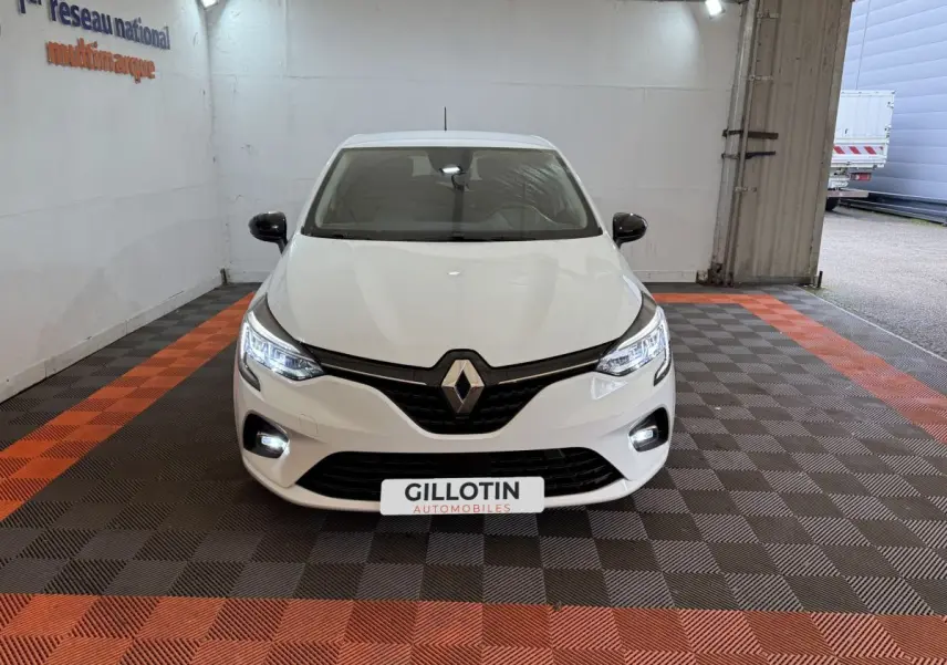 Renault Clio Business TCe 100 GPL blanc vue de face, avec phares LED allumés et logo Renault visible.