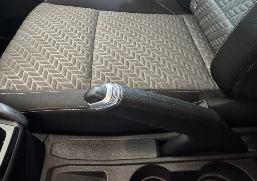 Gros plan sur le frein à main et la sellerie grise à motif chevrons de la Renault Clio Business 2023.