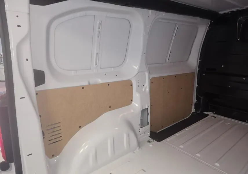 Vue intérieure arrière du fourgon blanc Opel Vivaro 2025, montrant les parois latérales avec panneaux de protection en bois.