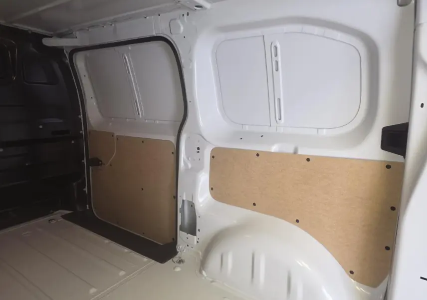 Intérieur du coffre blanc de l'Opel Vivaro 2025, vue latérale droite avec panneaux de protection en bois clair.