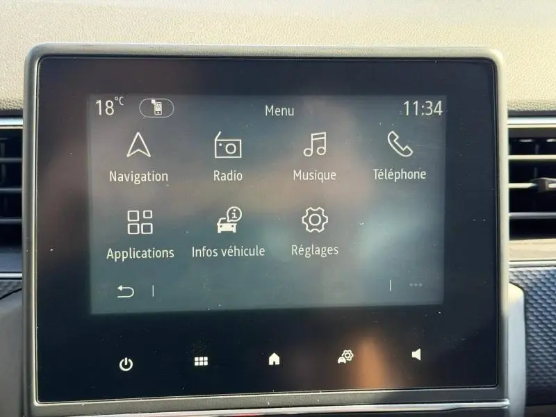 Écran tactile central du Renault Arkana 2025 affichant le menu principal avec navigation, radio et téléphone.