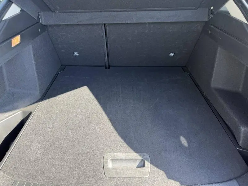 Vue plongeante sur le coffre spacieux et propre du Renault Arkana 2025, avec revêtement noir uniforme.