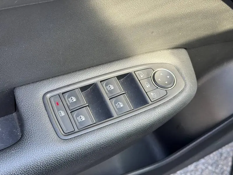 Gros plan sur les commandes de lève-vitres et rétroviseurs côté gauche d'une Renault Arkana gris métallisé 2025.