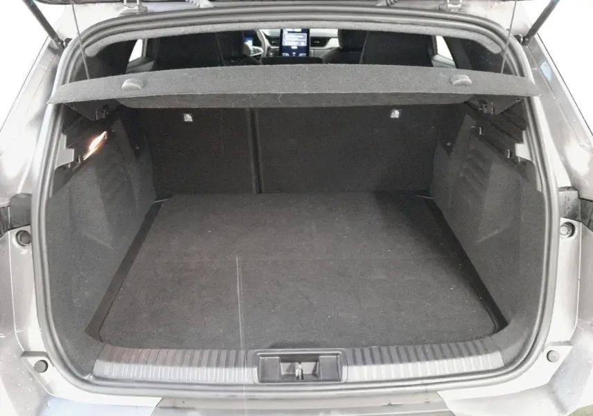 Coffre ouvert d’une Renault Symbioz gris cassiopée, vue arrière montrant l’espace de chargement et l’habitacle à l’avant.
