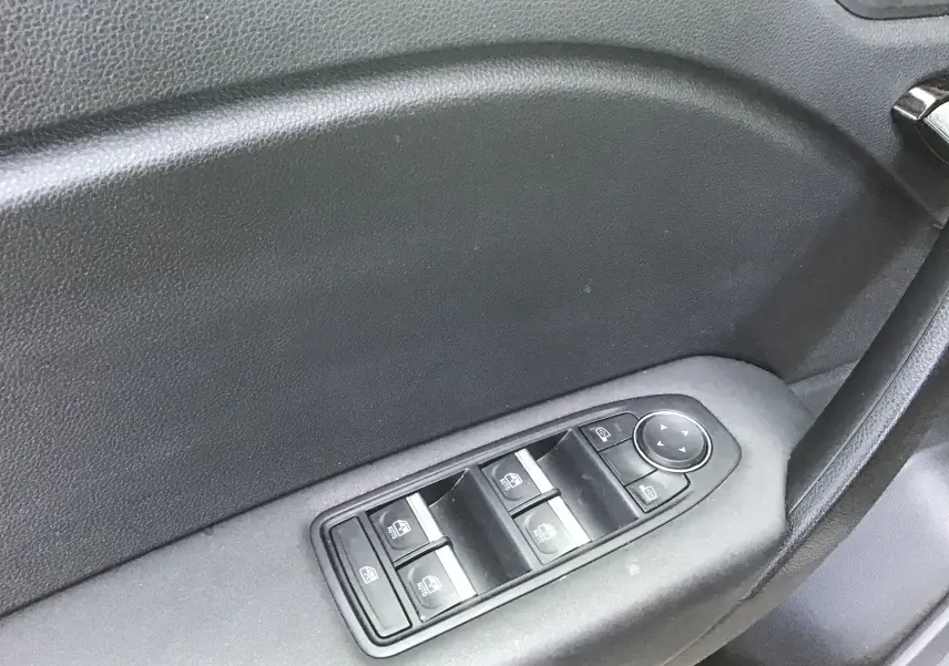 Gros plan sur les commandes de lève-vitres et réglage des rétroviseurs côté conducteur du Renault Symbioz gris Cassiopée 2025.