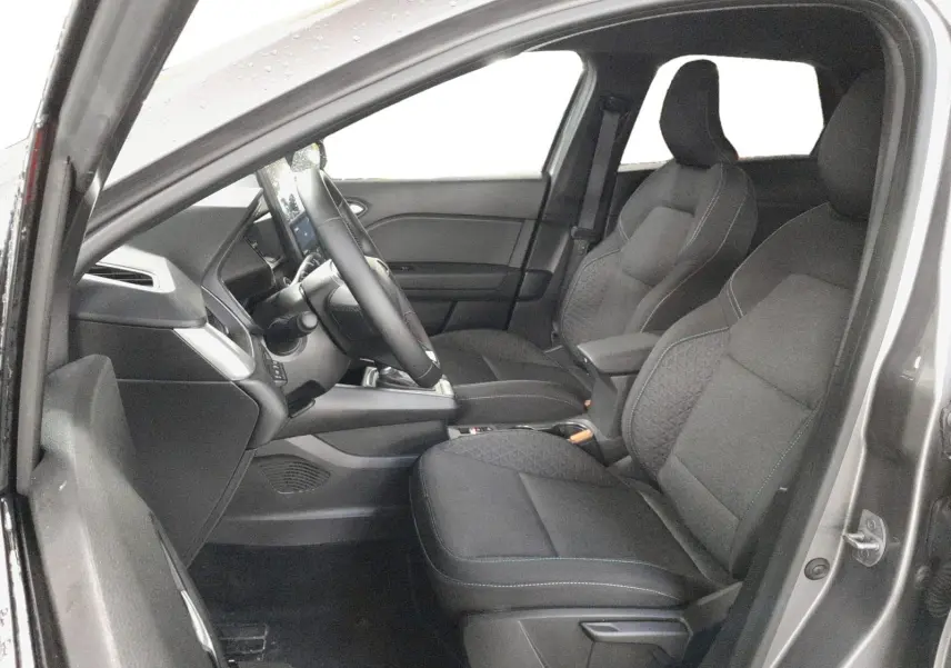 Vue intérieure côté conducteur du Renault Symbioz gris Cassiopée, montrant les sièges avant et le tableau de bord moderne.