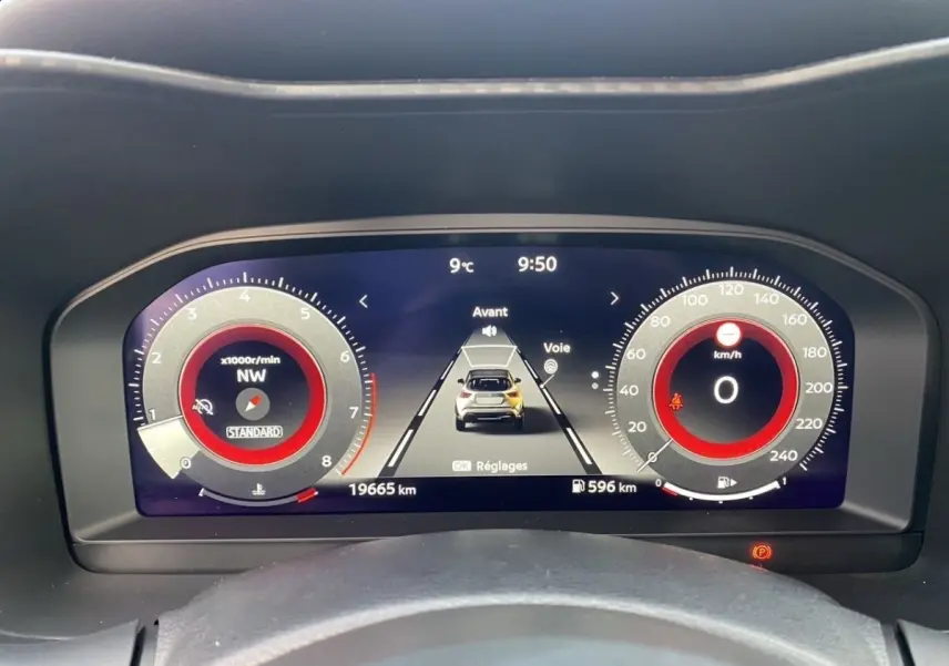 Vue rapprochée du tableau de bord numérique du Nissan Juke 2025, affichage rouge et noir avec compteur et vitesse à zéro.