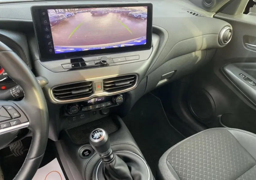 Vue intérieure côté conducteur du tableau de bord et écran tactile affichant la caméra de recul du Nissan Juke 2025.