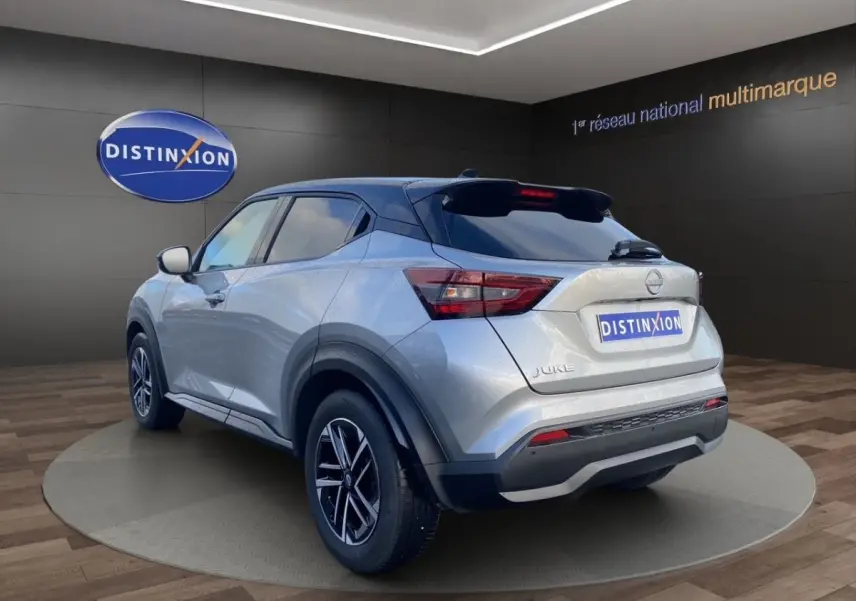 Nissan Juke gris clair vue 3/4 arrière droit, avec toit noir et jantes alliage distinctives.