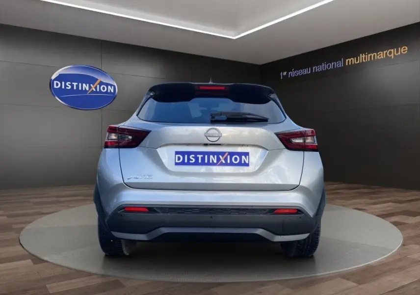 Vue arrière d'un Nissan Juke gris clair 2025, avec feux LED et logo Nissan bien visibles en showroom.