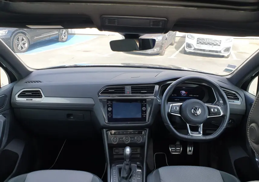 Vue intérieure du tableau de bord et volant à droite d'un Volkswagen Tiguan 2018, finition Carat, avec console centrale moderne.