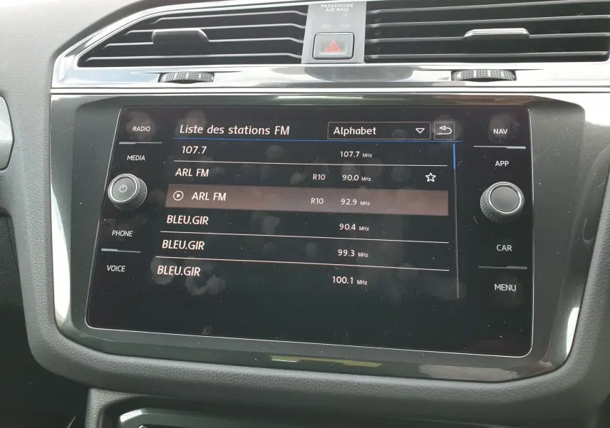 Écran tactile central du Volkswagen Tiguan 2018 affichant la liste des stations FM avec commandes autour.
