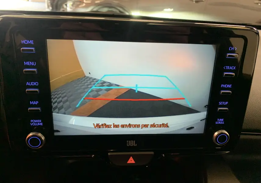 Écran multimédia de Toyota Yaris 2021 montrant la caméra de recul avec lignes de guidage colorées en bleu et rouge.